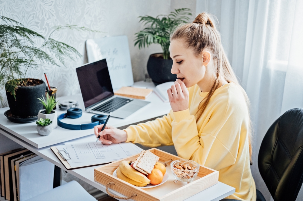 A person sitting at a desk eating healthy snacks